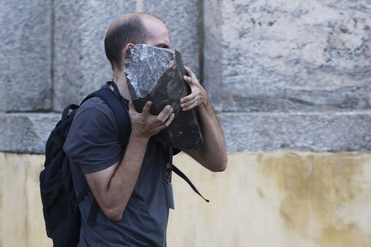 Pesquisadores e funcionários retiram peças dos escombros do Museu Nacional após incêndio.