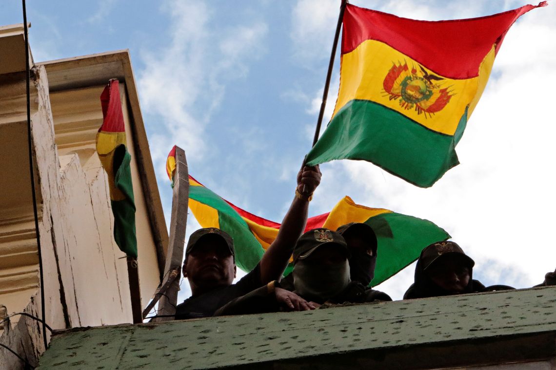 Police officers hold up Bolivian flags while delivering a statement on the roof of a police station during a protest against Bolivia&#039;s President Evo Morales in La Paz, Bolivia, November 9, 2019. REUTERS/Manuel Claure NO RESALES. NO ARCHIVES
