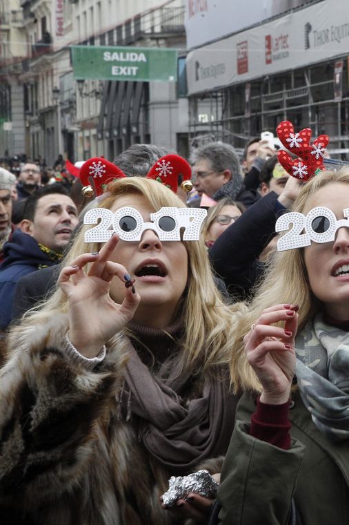 VICTOR LERENA/Lusa Madri - Espanholas seguem a tradição de comer uvas, na Praça del Sol, para comemorar da chegada do ano de 2017 (VICTOR LERENA/Lusa)