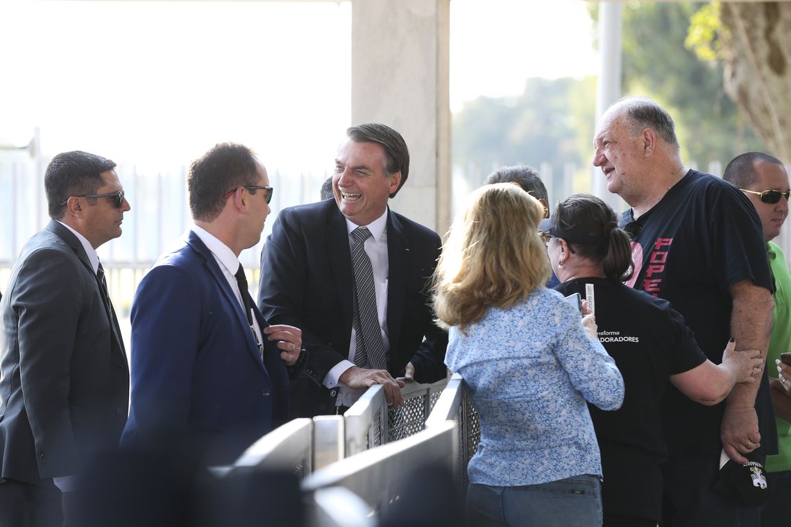 O presidente Jair Bolsonaro, cumprimenta populares  no Palácio da Alvorada