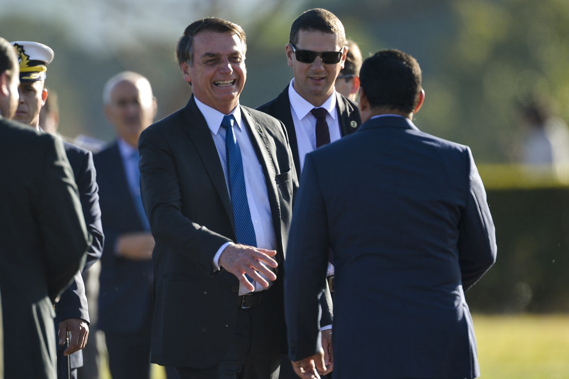 Marcelo Camargo/Agência Brasil O presidente Jair Bolsonaro, o vice-presidente Hamilton Mourão e ministros, participam de cerimônia de hastiamento da bandeira, no Palácio da Alvorada.