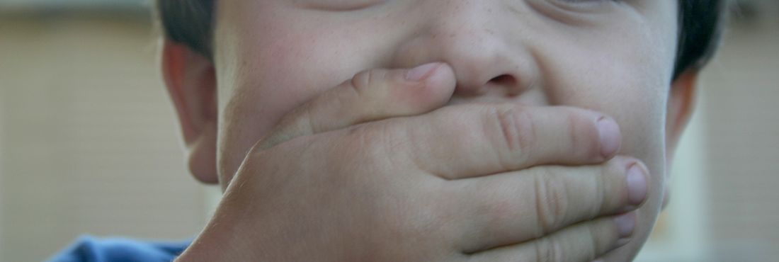Criança com a mão na boca Tampando a boca