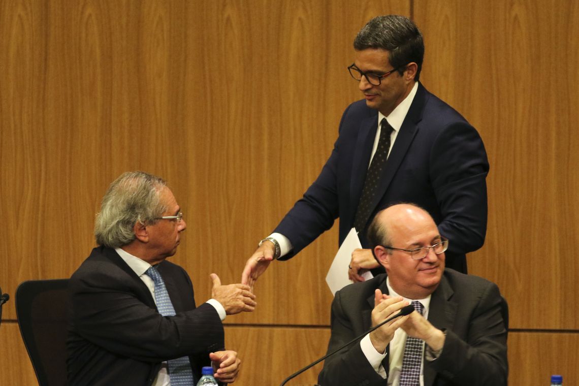 Fabio Rodrigues Pozzebom/Agência Brasil O novo presidente do Banco Central (BC), Roberto Campos Neto, o ministro da Economia, Paulo Guedes, e o ex-presidente do BC Ilan Goldfajn durante cerimônia de transmissão de cargo.