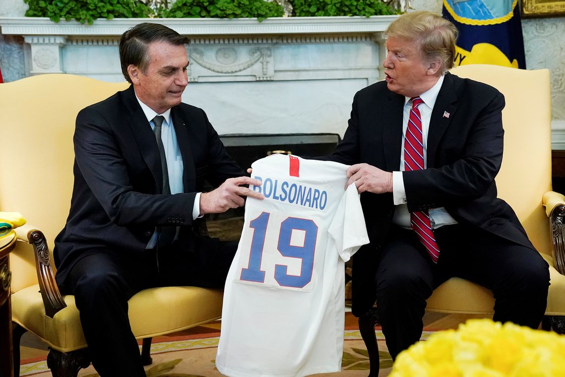 O presidente dos EUA, Donald Trump, dá ao presidente do Brasil, Jair Bolsonaro, uma camisa da seleção de futebol dos EUA durante uma reunião no Salão Oval da Casa Branca , em Washington (EUA).