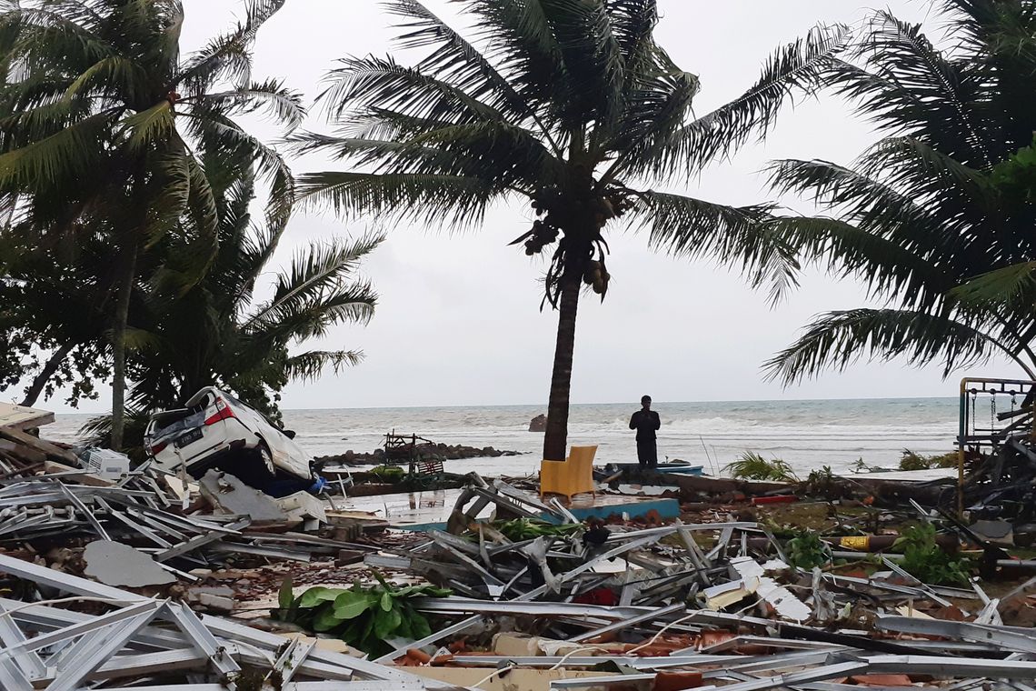 Um homem fica entre as ruínas após um tsunami na praia de Carita, em Pandeglang, na província de Banten