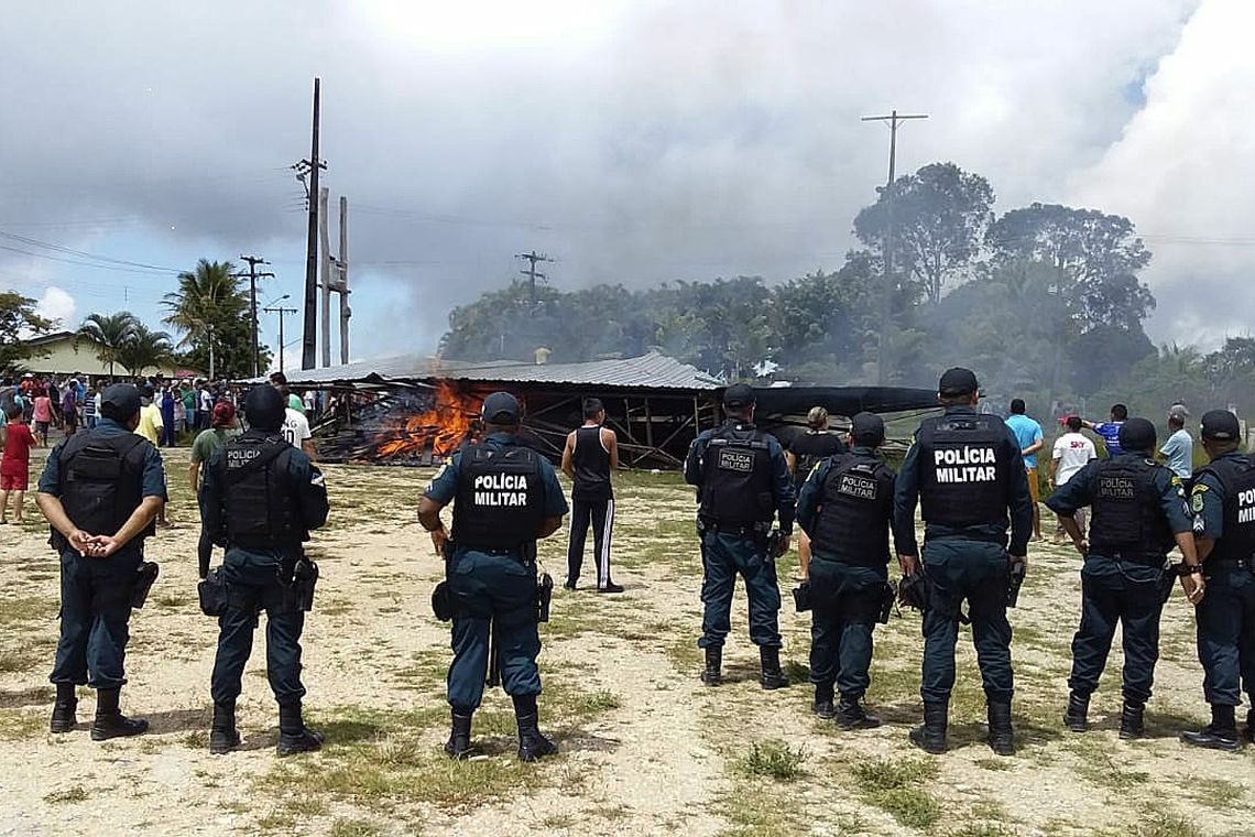 BRA03. PACARAIMA (BRASIL), 18/08/2018.- Policías brasileños prestan guardia mientras ciudadanos brasileños se manifiestan contra la presencia de inmigrantes venezolanos hoy, sábado 18 de agosto de 2018, en la localidad fronteriza de Pacaraima 