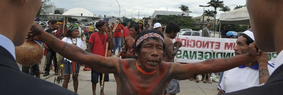 Índio dialoga com seguranças durante protesto Lideranças indígenas argumentam que as regras colocadas na Portaria 303 ameaçam um processo já consolidado