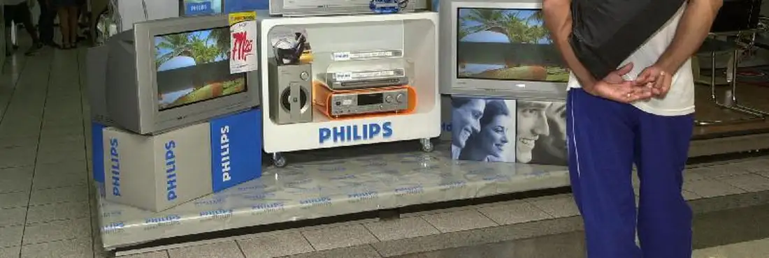 Comprador analisa aparelho de TV em frente a loja Comprador analisa aparelho de TV em frente a loja
