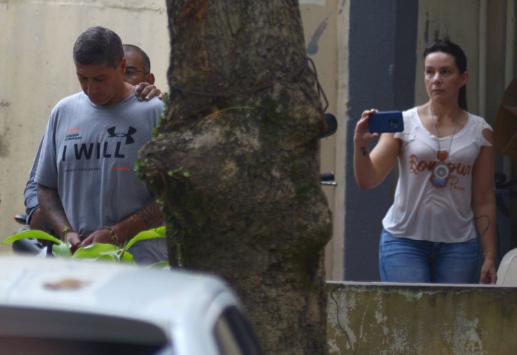 Ronnie Lessa, suspeito do assassinato da vereadora Marielle Franco, é escoltada por um policial quando ele deixa o departamento de homicídios para prestar depoimento na justiça Rio de Janeiro.