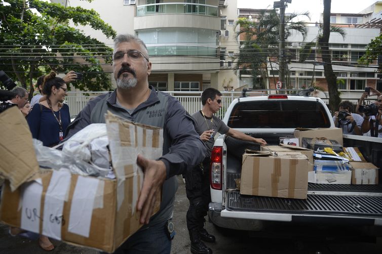 Policiais carregam caixas apreendidas em endereÃ§o ligado a suspeito de matar a vereadora Marielle Franco e o motorista Anderson Gomes em 14 de marÃ§o de 2018.