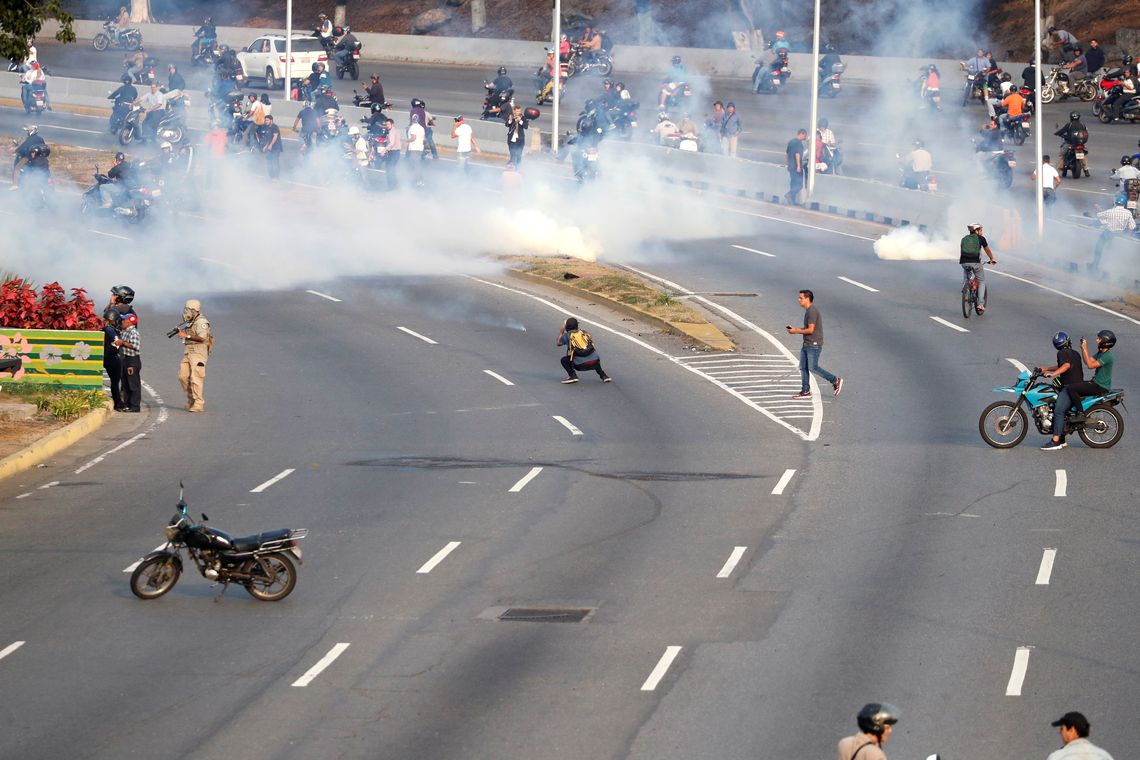 PartidÃ¡rios da oposiÃ§Ã£o venezuelana reagem ao gÃ¡s lacrimogÃªneo perto da Base AÃ©rea &quot;La Carlota&quot;, em Caracas, Venezuela.