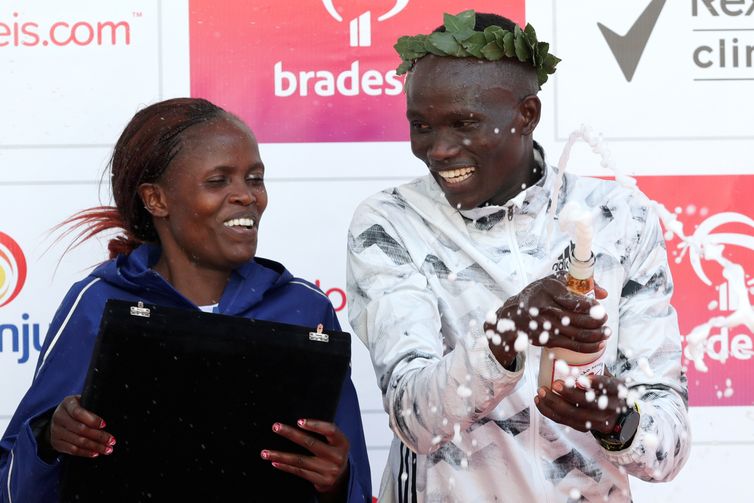 Brigid Jepchirchir Kosgei e Kibiwott Kandie do Quênia comemoram no pódio depois de vencer a corrida anual &quot;São Silvestre&quot;