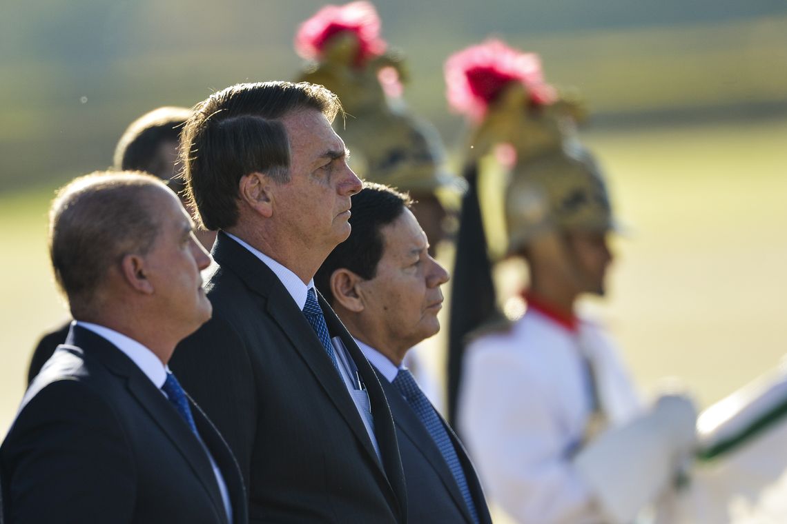Marcelo Camargo/Agência Brasil OMinistro-chefe da Casa Civil, Onyx Lorenzoni, o presidente Jair Bolsonaro e o vice-presidente Hamilton Mourão, participam de cerimônia de hastiamento da bandeira, no Palácio da Alvorada. (Foto: Marcelo Camargo/Agência Brasil)