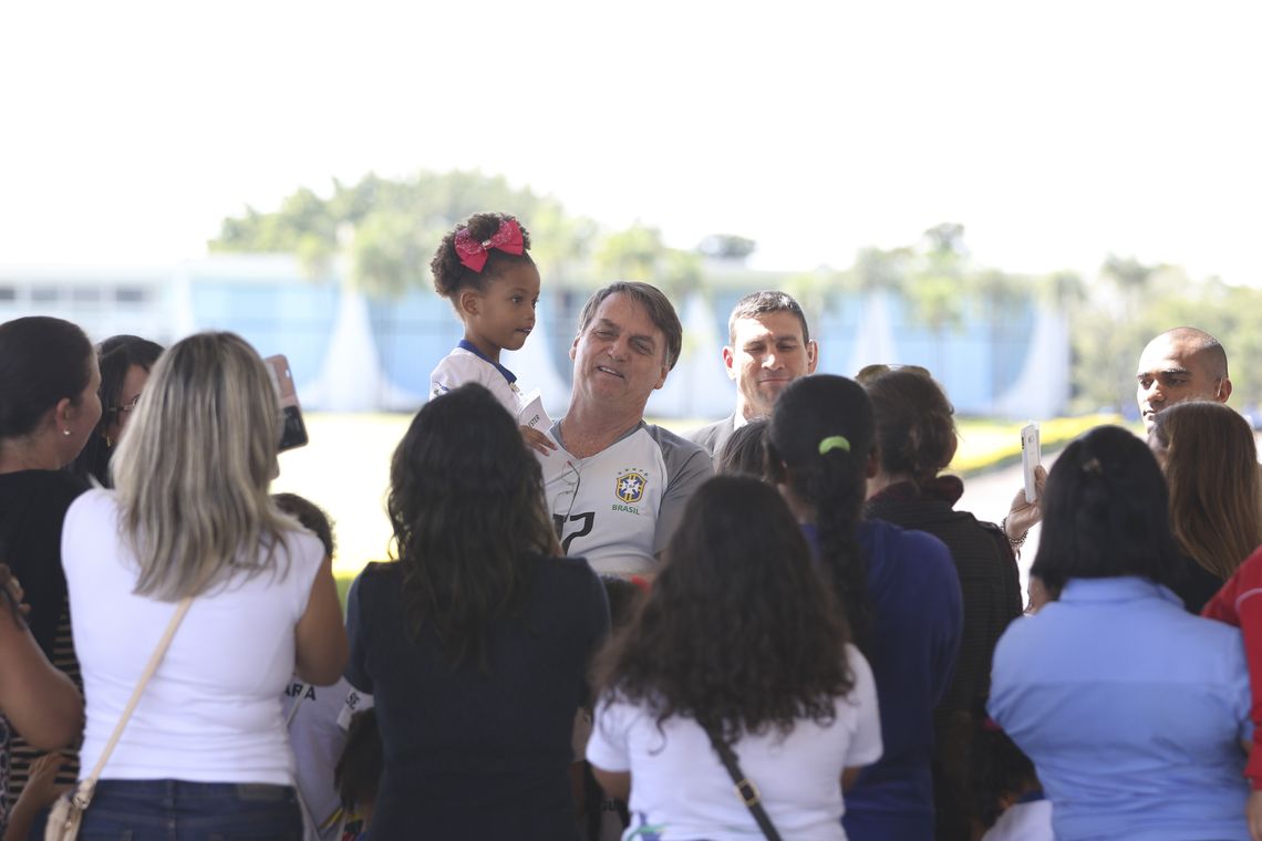O presidente Jair Bolsonaro vem até a entrada do Palácio da Alvorada, e conversa com crianças e posa para fotos.