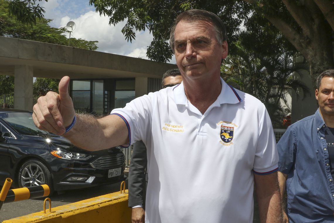 O presidente Jair Bolsonaro, cumprimenta populares e posa para fotos na saída do Palácio da Alvorada, na manhã deste Domingo.