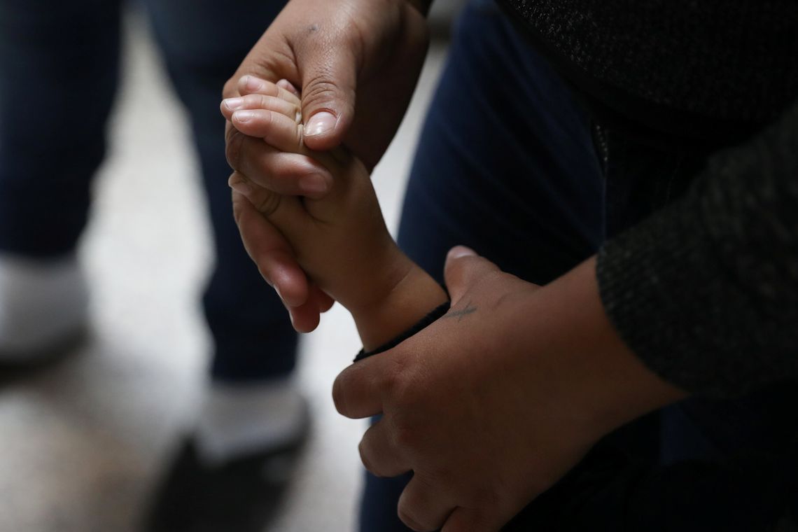 Uma mulher segura a mÃ£o de uma crianÃ§a enquanto famÃ­lias de imigrantes ilegais sÃ£o libertadas da detenÃ§Ã£o no Texas, nos Estados Unidos 
