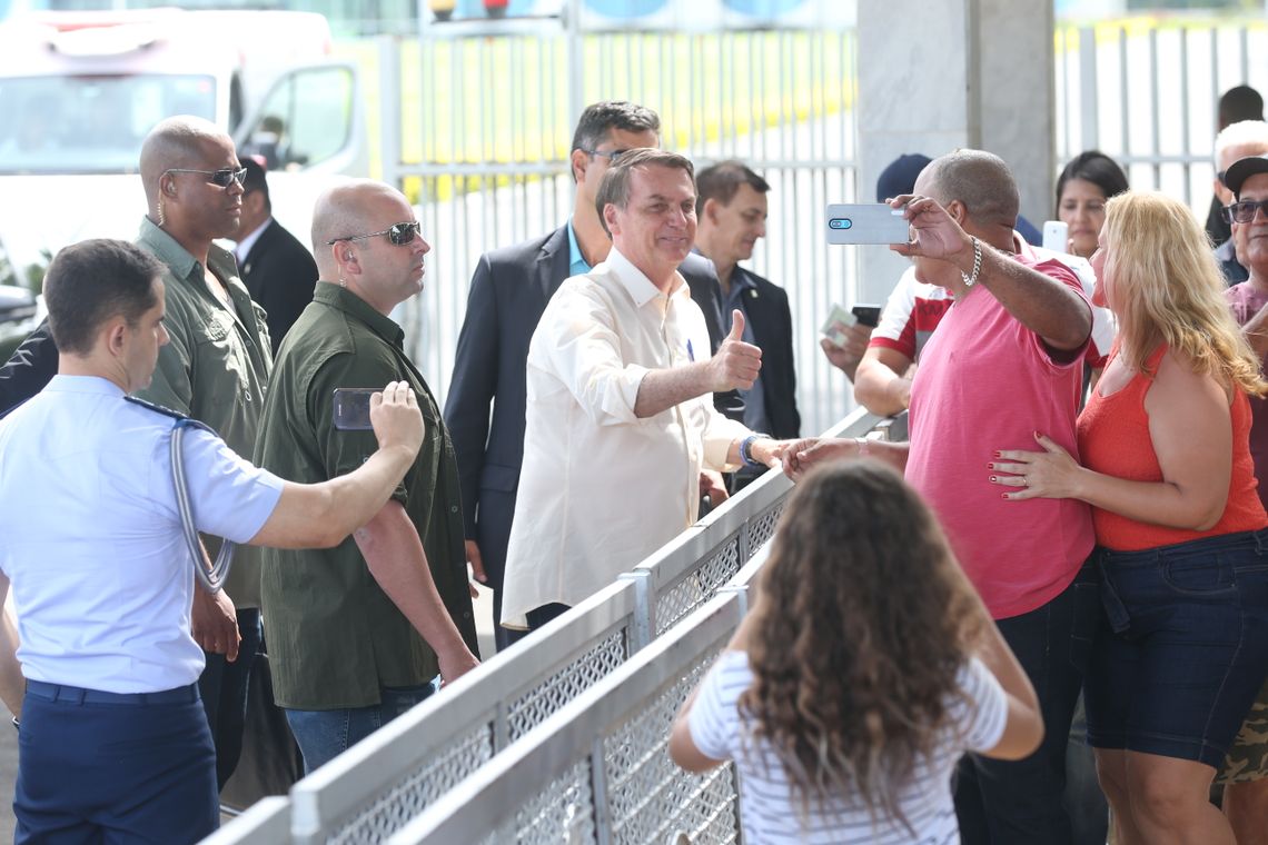 O Presidente Jair Bolsonaro cumprimenta  populares ao sair do Palácio da Alvorada