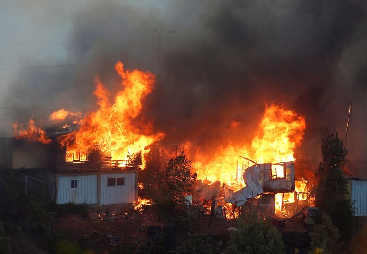Houses burn following the spread of wildfires in Valparaiso, Chile, December 24, 2019. REUTERS/Rodrigo Garrido