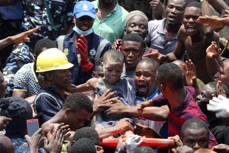 Men carry a boy who was rescued at the site of a collapsed building containing a school in Nigeria&#039;s commercial capital of Lagos, Nigeria March 13, 2019. REUTERS/Temilade Adelaja