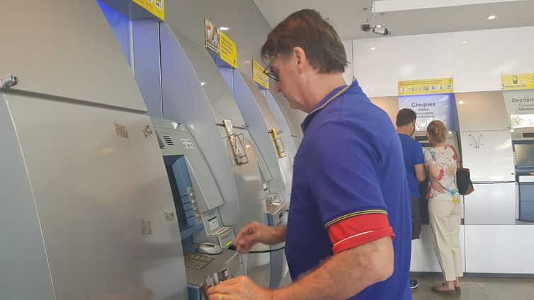 Bolsonaro no caixa eletrônico de uma agência bancária