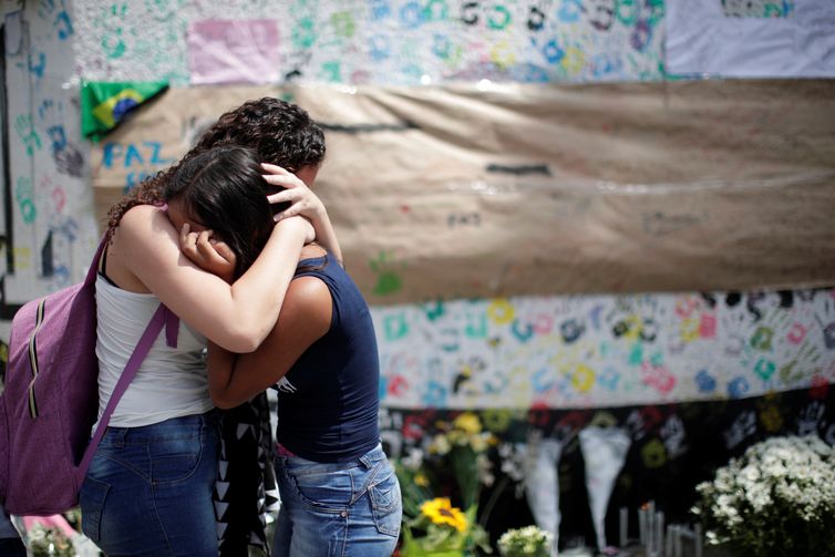 Alunos choram perto de uma parede durante um dia de reabertura da escola, após o tiroteio na escola Raul Brasil em Suzano, estado de São Paulo, Brasil 18 de março de 2019. 