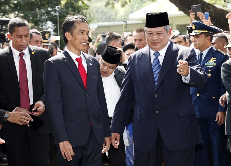 Novo presidente da Indonesia Joko Widodo (à esquerda) é cumprimentado pelo ex-presidente Susilo Bambang Yudhoyono (à direita) em uma cerimônia militar no palácio presidencial, na capital Jacarta
