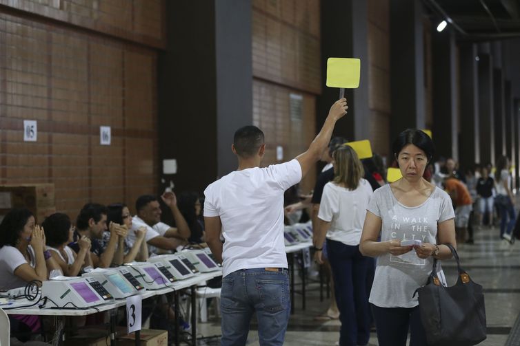  Eleitores que estão fora do domicílio eleitoral justificam a ausência na votação em um posto localizado em um shopping no centro de Brasília.