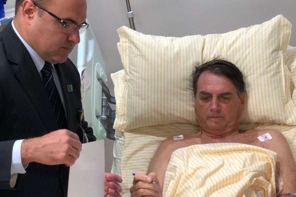 O presidente Jair Bolsonaro assina decretos no hospital 