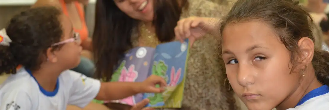 Menina, durante a leitura do livro Menina ouve a leitura do livro