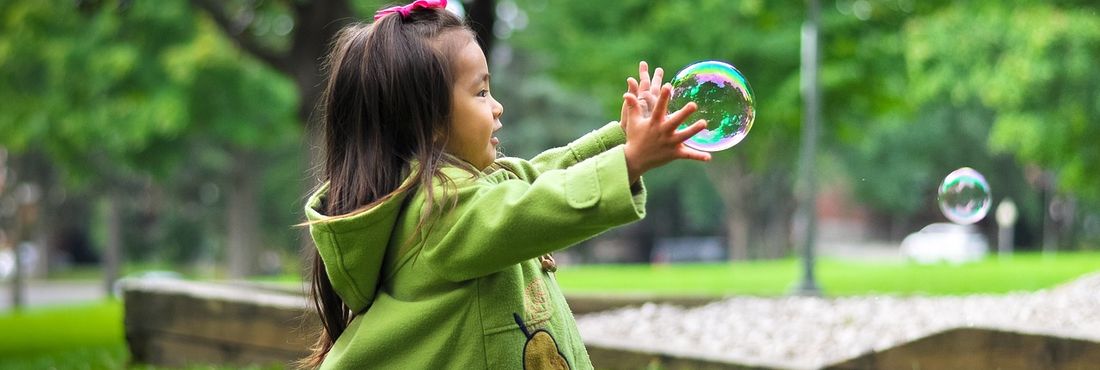 Menina brincando com bolinha de sabão