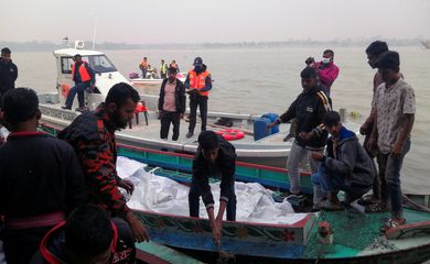 Rescue workers bring bodies on a boat, who died after a fire broke out in a passenger ferry on Sugandha River in Jhalalathi