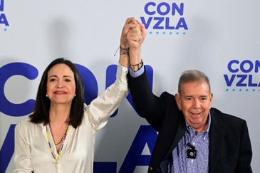 Venezuelan opposition leader Maria Corina Machado and opposition presidential candidate Edmundo Gonzalez raise their hands during a press conference following the announcement by the National Electoral Council that Venezuela's President Nicolas Maduro won the presidential election, in Caracas, Venezuela, July 29, 2024. REUTERS/Maxwell Briceno