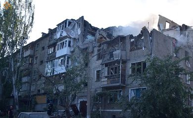 Membro de equipe de resgate perto de prédi residencial atingido por ataque militar russo em Mykolaiv, na Ucrânia