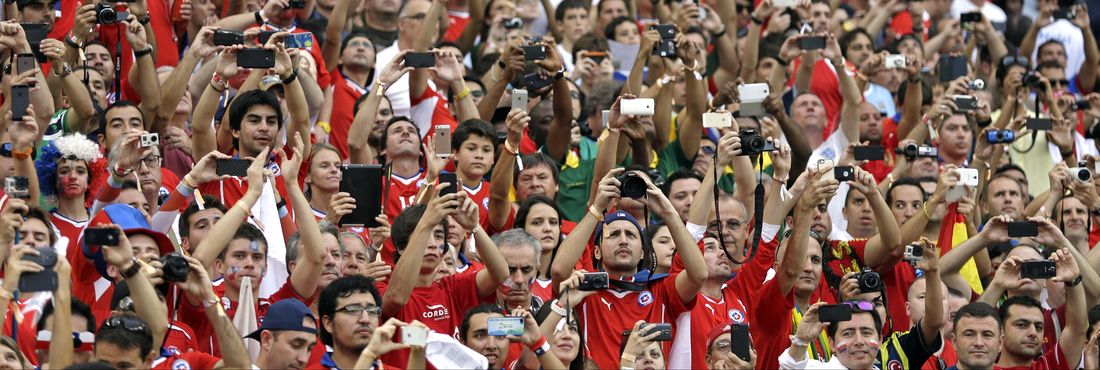 Torcida chilena usa celulares para fotografar seleção no jogo contra a Espanha no Maracanã pelo grupo B da Copa do Mundo