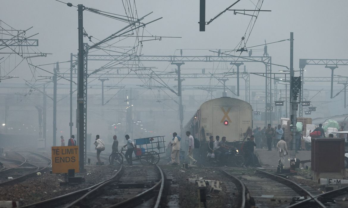 People cross railway tracks on a smoggy morning in New Delhi, India, November 3, 2023. REUTERS/Anushree Fadnavis