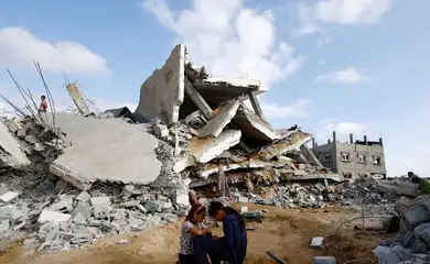 Crianças palestinas sentam-se perto de casa demolida por um ataque israelense em Rafah, no sul da Faixa de Gaza
21/04/2024
REUTERS/Mohammed Salem