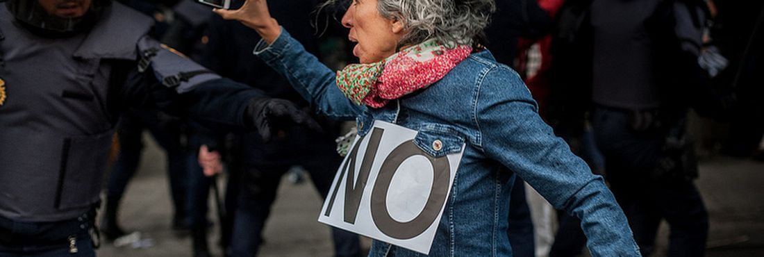 Manifestante fotografa ação policial durante protesto na Espanha