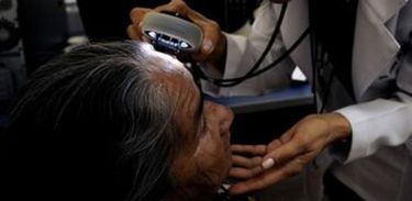 Médica examina pele de paciente idosa