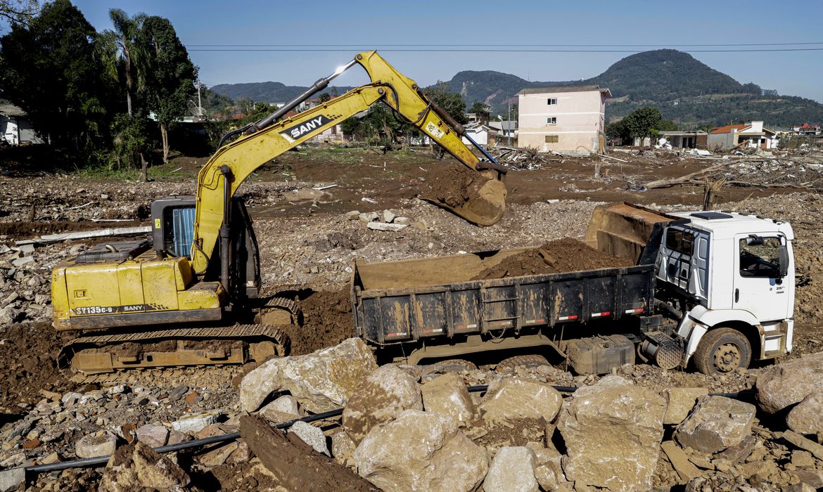 Roca Sales (RS), 22/06/2024 -  Retroescavadeira faz limpeza de terreno em frente a casas destruídas após enchente que atingiu toda a região. Foto: Bruno Peres/Agência Brasil