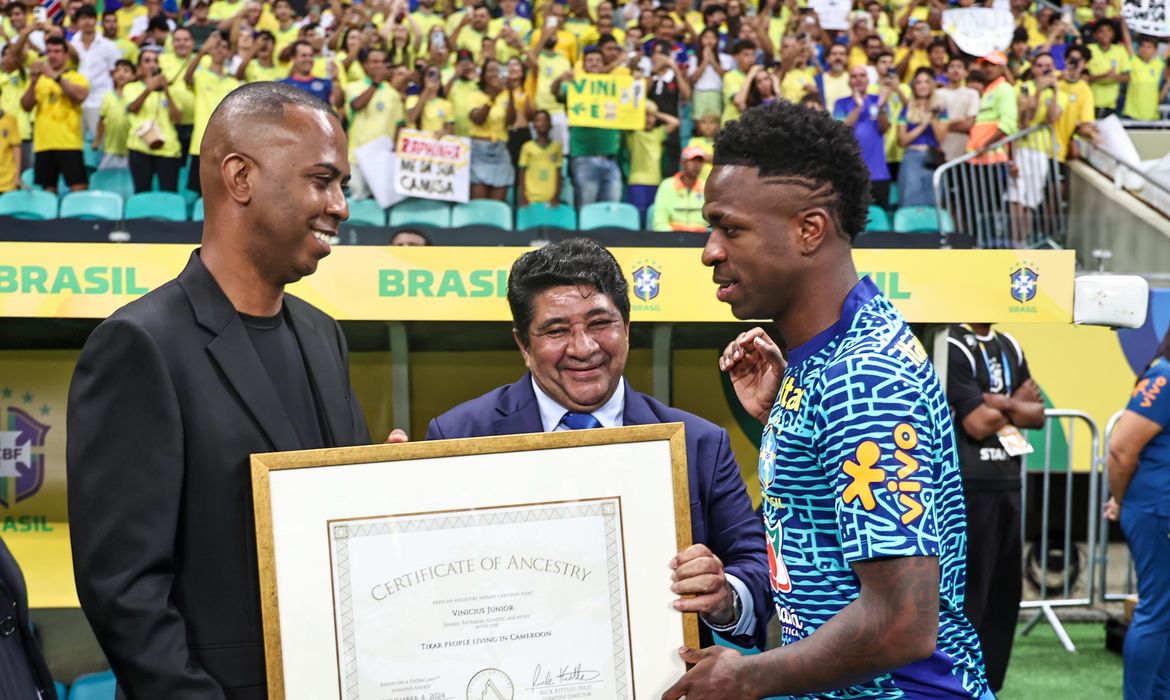 André Frutuôso/CBF/Direitos Reservados Vini Jr recebe certificado de ancestralidade antes de Brasil x Uruguai, na Arena Fonte Nova, em 19/11/2024