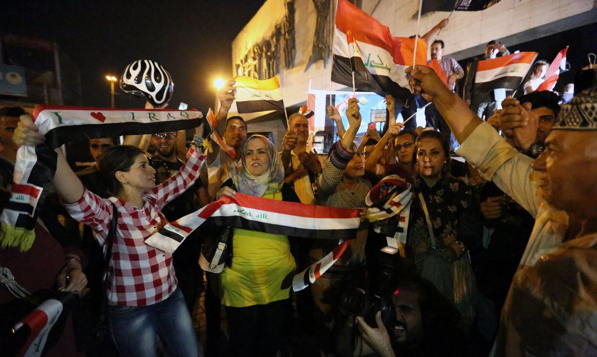 Iraquianos comemoram na Praça Tahir, em Bagdá, a libertação de Mosul do Estado Islâmico