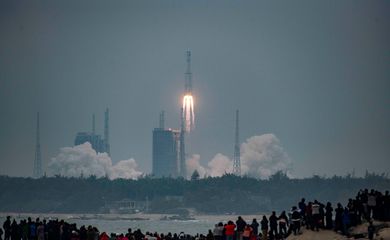 Pessoas assistem lançamento do foguete Longa Marcha 8 Y-1 em Hainan, na China
