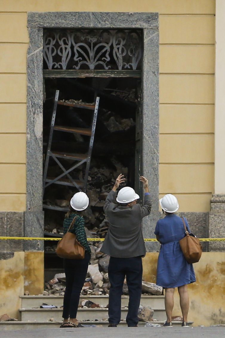 A chefe da missão da Unesco, Cristina Menegazzi (de vestido), chega para avaliar o resgate nos escombros e reconstrução do patrimônio no Museu Nacional do Rio de Janeiro, após o incêndio.