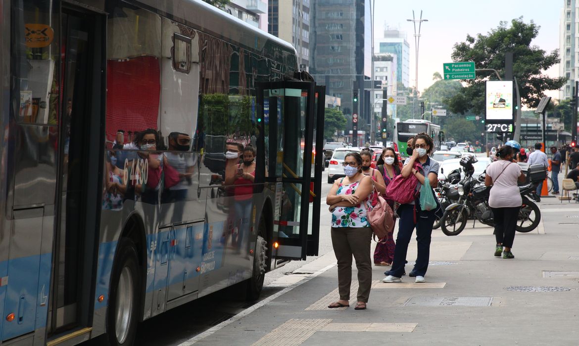 Usuários do transporte público esperam ônibus em ponto da Avenida Paulista, durante a fase vermelha da pandemia de covid-19 na capital.