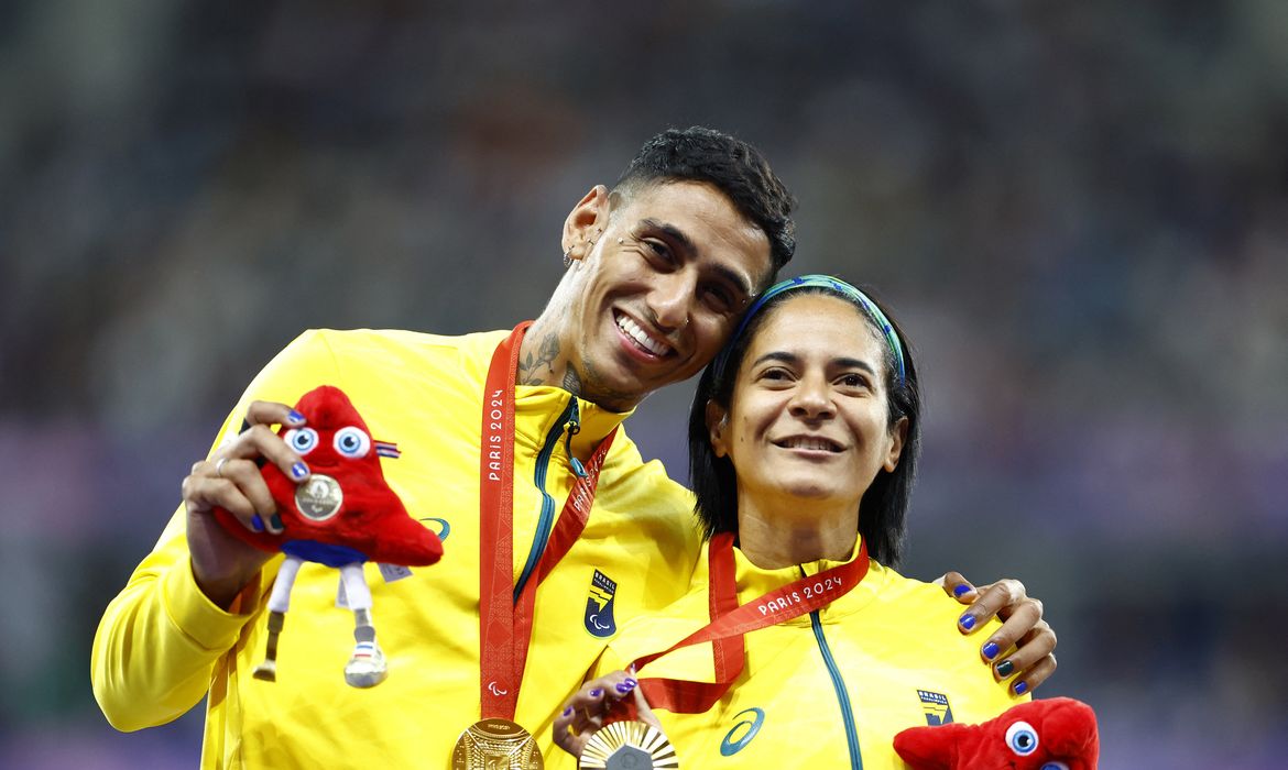 Paris 2024 Paralympics - Athletics - Women's 100m - T11 Medal Ceremony - Stade de France, Saint-Denis, France - September 3, 2024 Gold medallist Jerusa Geber dos Santos of Brazil and guide Gabriel Aparecido dos Santos Garcia celebrate on the podium REUTERS/Thomas Mukoya