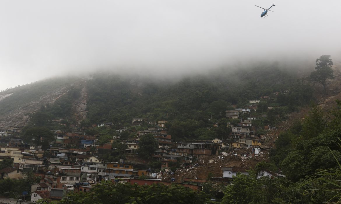 Tânia Rêgo/Agência Brasil Bombeiros, moradores e voluntários trabalham no local do deslizamento no Morro da Oficina, após a chuva que castigou Petrópolis, na região serrana fluminense