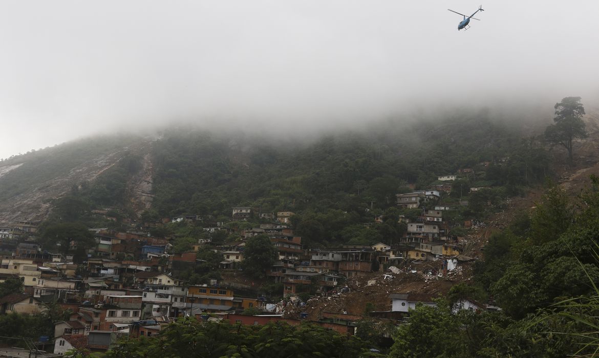 Bombeiros, moradores e voluntários trabalham no local do deslizamento no Morro da Oficina, após a chuva que castigou Petrópolis, na região serrana fluminense