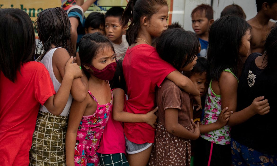Crianças fazem fila para receber comida grátis distribuída por programa assistencial em favela em Manila, nas Filipinas, em meio à pandemia de Covid-19