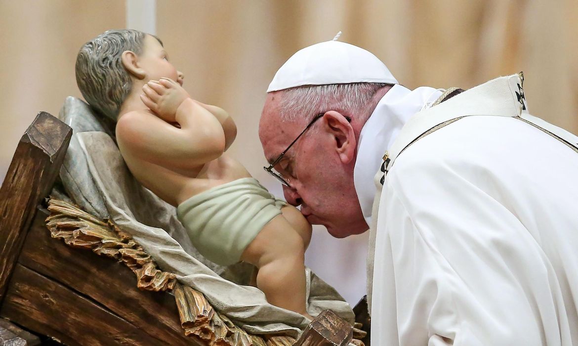 Papa Francisco beija o menino Jesus durante a missa do galo na Basílica de São Pedro