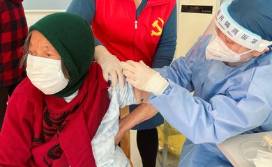 Profissional de saúde aplica vacina contra Covid-19 em idosa nos arredores de Xangai